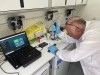 A male Hub colleague uses water sampling equipment on a workbench in the lab in a van thumbnail